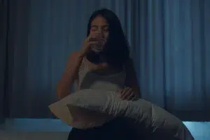 Mujer con ansiedad por la noche bebiendo agua